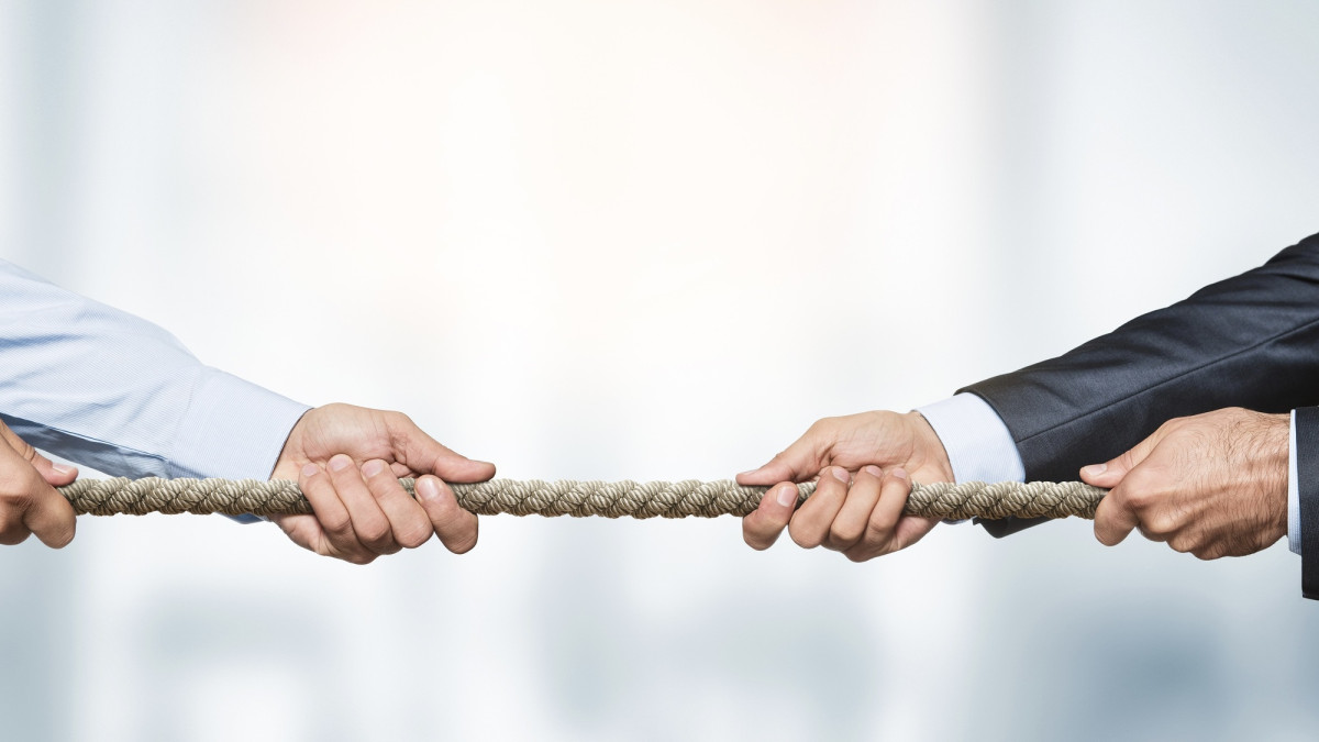 Tauziehen, zwei Geschäftsleute ziehen ein Seil in entgegengesetzte Richtungen