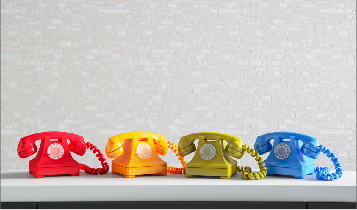 Mehrere bunte alte Telefone stehen nebeneinander