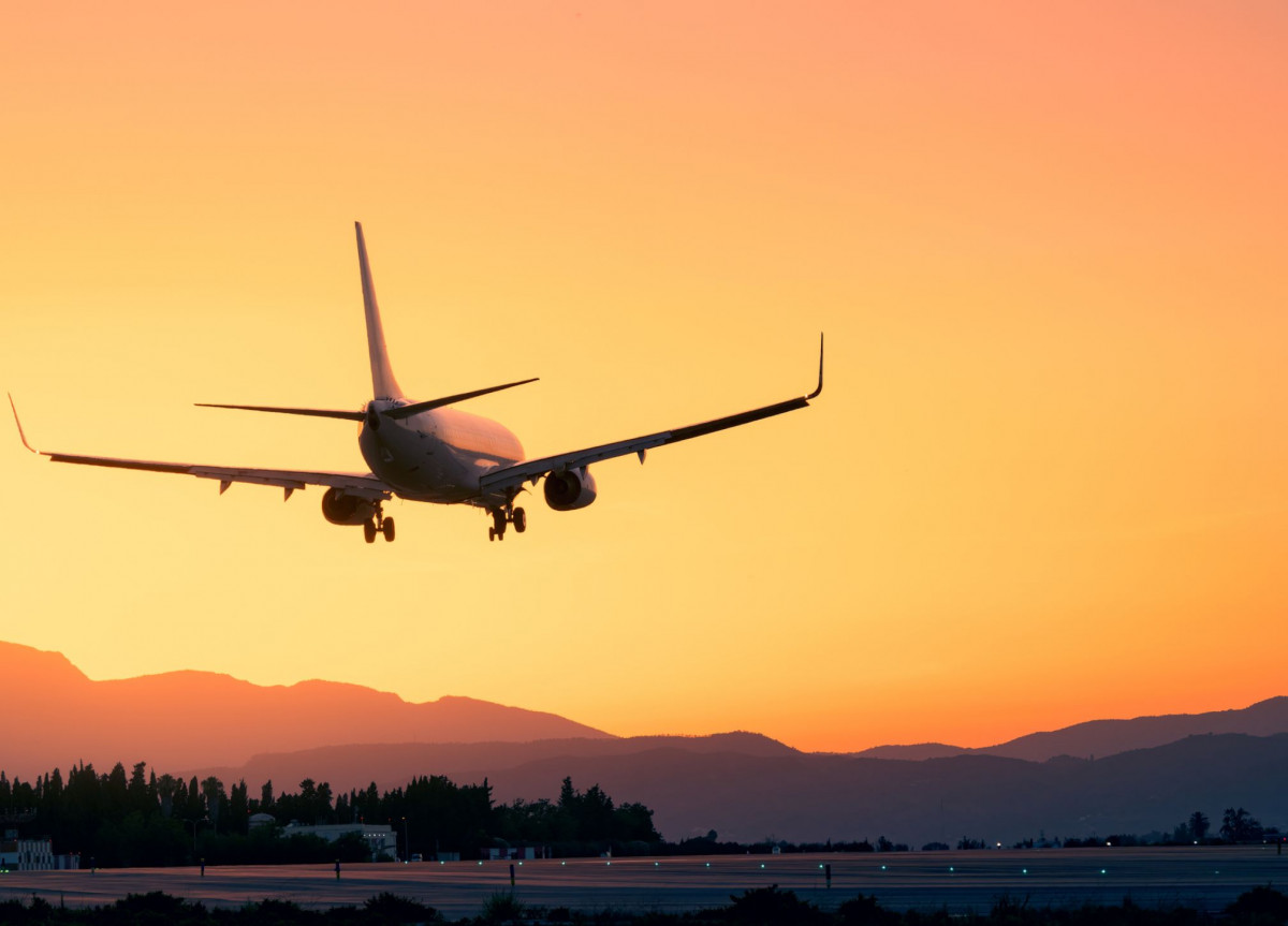 Ein Flugzeug landet bei aufgehender Sonne