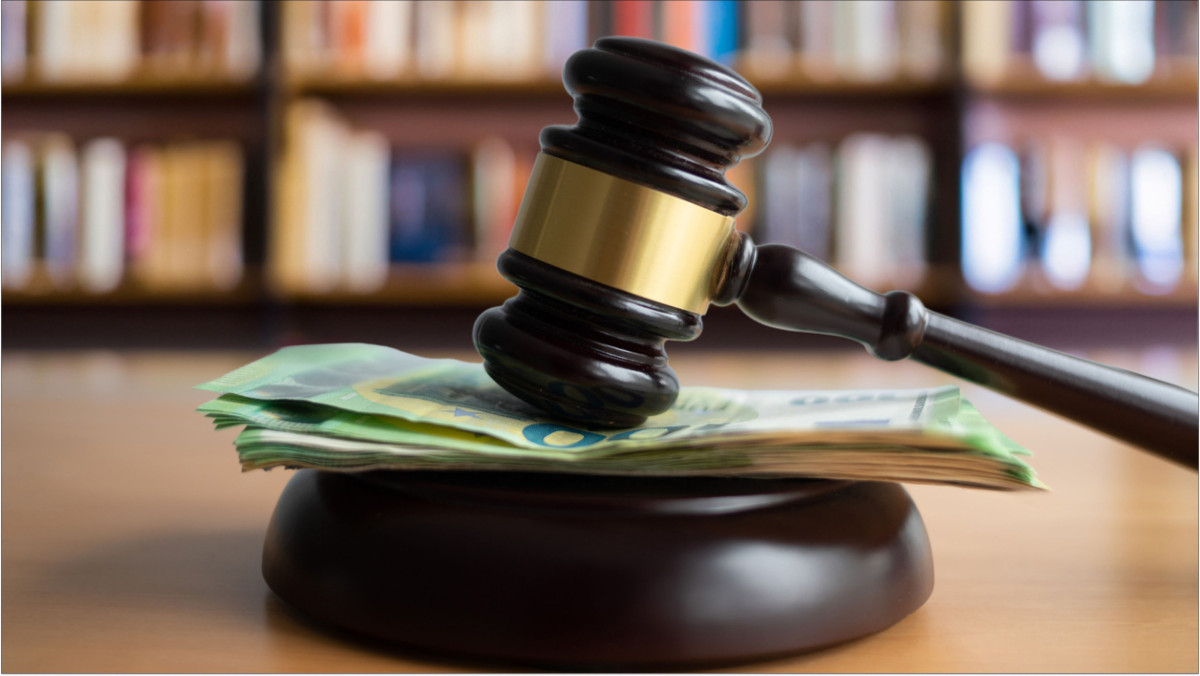 Ein Richterhammer liegt auf einem Bündel Hundert-Euro-Scheine