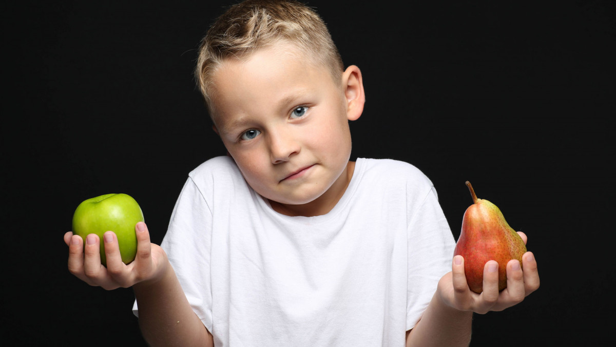 Junge mit Apfel und Birne in der Hand