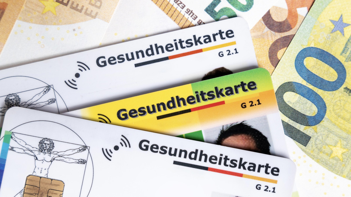Mehrere Gesundheitskarten liegen auf Euroscheinen.