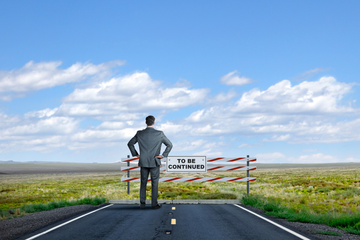 Ein Mann steht am Ende einer Straße mit dem Schild: to be continued.
