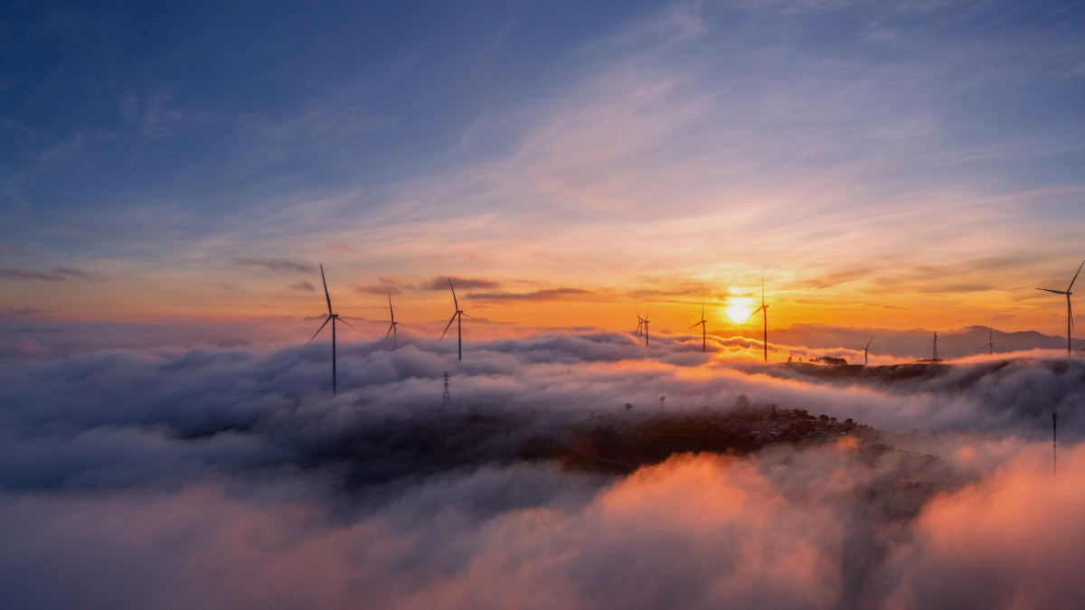Windkraftanlage über den Wolken im Sonnenuntergang